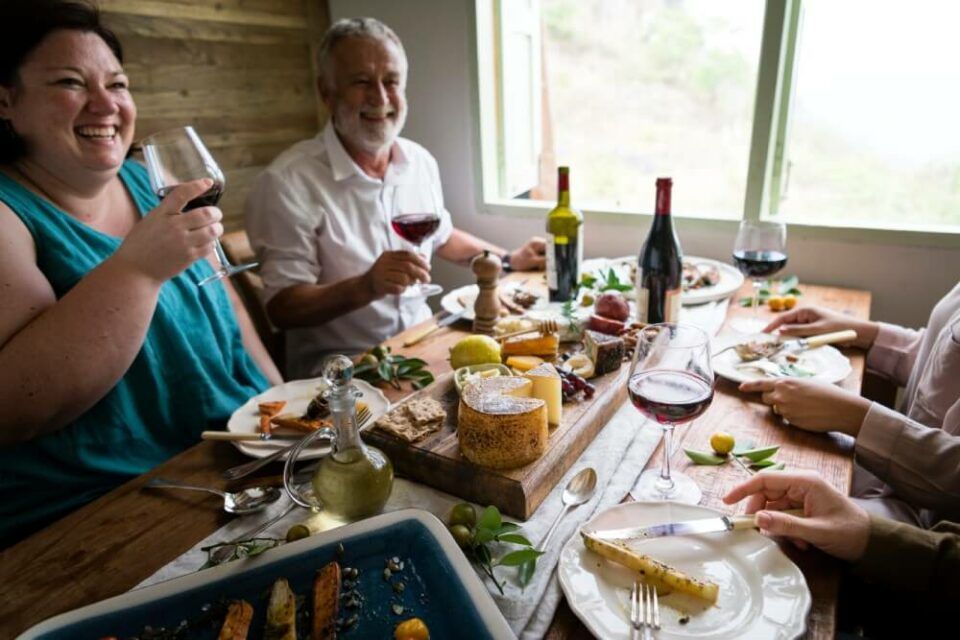 Menschen am Esstisch essen und trinken Wein